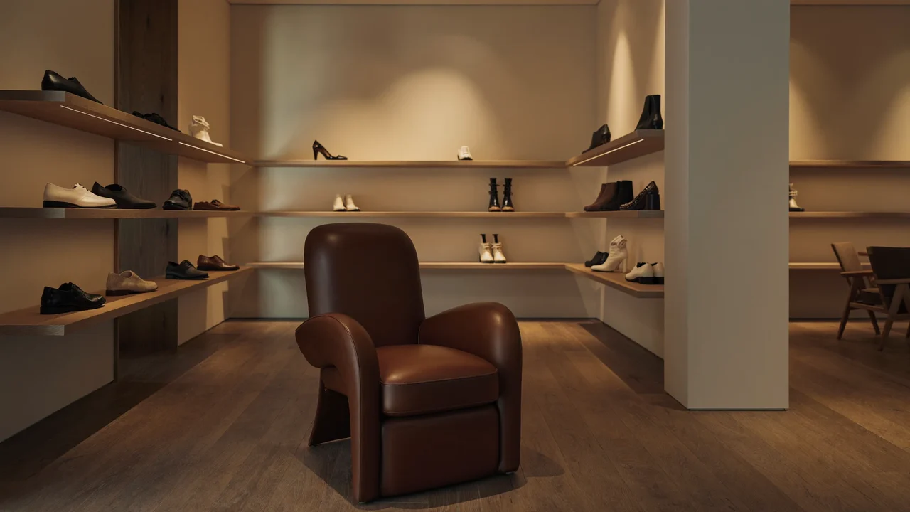 Interior de boutique cu rafturi minimaliste și un fotoliu din piele
